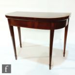 A George III crossbanded mahogany D shaped folding card table on line inlaid legs terminating in