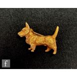 A 15ct brooch modelled as a standing terrier dog, length 2.5cm, height 2cm, weight 10g, stamped
