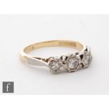 A mid 20th Century 18ct diamond three stone ring, transitional cut illusion set stones to platinum