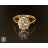 A 9ct hallmarked blue topaz and diamond cluster ring, central oval topaz within an oval set