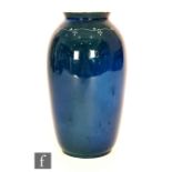 Ruskin Pottery - A souffle glaze vase decorated in a mottled green over dark blue with a hand