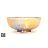 Ruskin Pottery - A small footed eggshell bowl decorated in a mottled blue and yellow lustre,