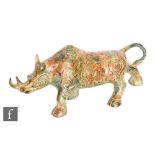 A Chinese Archaic style metalwork figure of a rhinoceros, cast in striding position with taotie