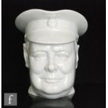 A Minton Winston Churchill character jug modelled by Eric Owen, the whole glazed in pale blue, red