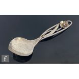 An Arts and Crafts Australian Sterling silver spoon, hammered bowl rising to a pierced handle with