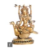 A Sino-Tibetan figure of Avalokitesvara, cast seated on bird, holding a ritual axe aloft, and