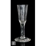 An 18th Century drinking glass, circa 1740, the elongated ogee bowl above a plain stem raised to a