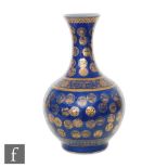 A Chinese Guangxu (1875-1908) powder-blue bottle vase, rising from a high footring, the flecked rich