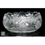 An early 20th Century glass bowl of oval section with wave rim, cut with flowers and leaves,