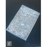A hallmarked silver rectangular card case decorated with chased foliate scrolls and fruiting vine