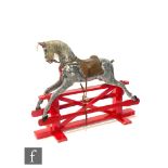 An early 20th century and later painted dapple grey rocking horse on swing trestle base, length