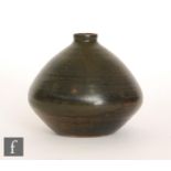 A studio pottery vase decorated in an all over dark green black glaze with a brown band to the