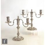 A pair of hallmarked silver cast squat twin light candelabrum, shaped octagonal bases with mask