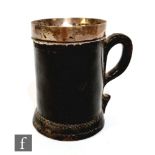 A small 18th Century Blackjack stitched leather silver banded tankard, 10.5cm.