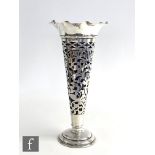 A hallmarked silver trumpet vase, circular stepped foot below foliate pierced body and crimped