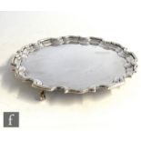 A hallmarked silver card waiter of plain form with scalloped border, diameter 20cm, weight 12.5oz,