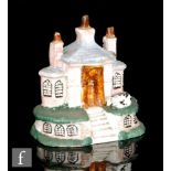 A 19th Century pearlware model of a building, possibly a bank, with painted windows and a seated
