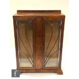 A 1930s Art Deco figured walnut display cabinet enclosed by a pair of bar glazed doors, 125cm x 33cm