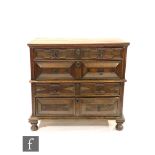 An 18th century oak geometric moulded front chest of four long drawers, conforming panel ends, brass