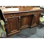 A Victorian mahogany inverted breakfront sideboard, three frieze drawers over a cupboard base,