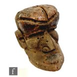 A carved African face or head mask with pronounced nose, brow and lips, with drilled hole decoration