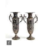 A pair of hallmarked silver twin handled bud vases each with embossed figures in a landscape setting