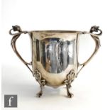 An Art Nouveau hallmarked silver twin handled ice bucket of plain form raised on four scroll feet