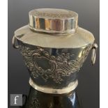 A silver hallmarked tea caddy of tapered oval form, with embossed floral and scrolling decoration