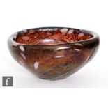 A studio glass bowl of tapering form, decorated with iridescent twisted ribbed body over a