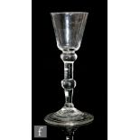 An 18th Century drinking glass circa 1740, the round funnel bowl above a balustroid stem with