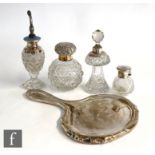 Three hallmarked silver clear cut glass scent bottles, an atomiser and a silver backed hand