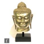 A large and decorative silvered metal Buddha head, the features relief cast with downcast eyes and