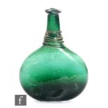 An early 19th Century Persian green glass saddle flask of compressed ovoid form with tall tapered