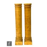 A pair of 20th Century stripped pine Doric columns with cushion tops, heights 140cm.