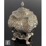 A silver hallmarked tea caddy of bombe form, embossed with scrolling and floral decoration,