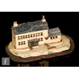 A later 20th Century craft made model of a farmhouse building or weavers cottage on a shaped oval