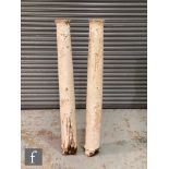 A pair of white painted soft wood Doric columns each on a later white composite plinth base,