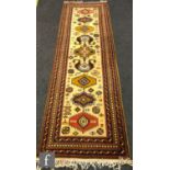 A Kashan style runner, the central ochre ground with medallions and geometric designs within a