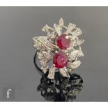 An 18ct white gold plated silver ruby and diamond cluster ring, two central oval rubies to an