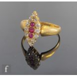 An early 20th Century ruby and diamond marquise shaped ring, three central rubies within a twelve