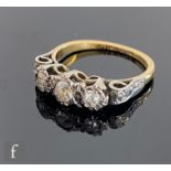 An 18ct mid 20th Century diamond three stone ring, illusion set stones to scroll shoulders, total