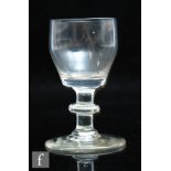 An 18th Century dram glass circa 1780, the barrel form bowl above a plain stem with bladed knop
