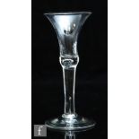 An 18th Century drinking glass circa 1740, the flared trumpet bowl over a plain stem with internal