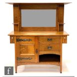 An Arts and Crafts oak sideboard attributed to Liberty & Co, the mirror panel upright with