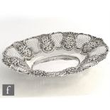 A hallmarked silver oval dish with pierced and foliate embossed border encompassing a plain well,