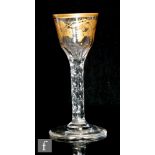 An 18th Century drinking glass circa 1770, the ogee bowl with basal flutes decorated with gilt rim