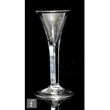 An 18th Century drinking glass circa 1750, the trumpet bowl above a teared plain stem and folded