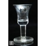 An 18th Century dram glass circa 1750, the bell form bowl above a plain stem and raised to a solid