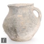 A Chinese Han Dynasty (202 BC-220 AD) grey earthenware single-handled cup of ovoid form and flared