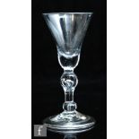 An 18th Century heavy baluster wine glass circa 1720, the bell bowl with solid base over an inverted
